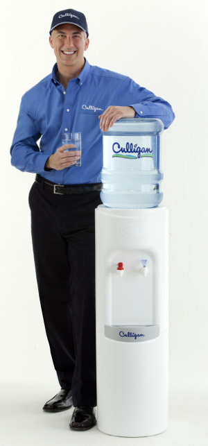 Culligan Man Standing Next to Bottled Water Cooler.